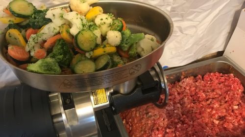 image of raw dog food preparation. All the raw meat was put through the grinder and now the vegetables will be added.